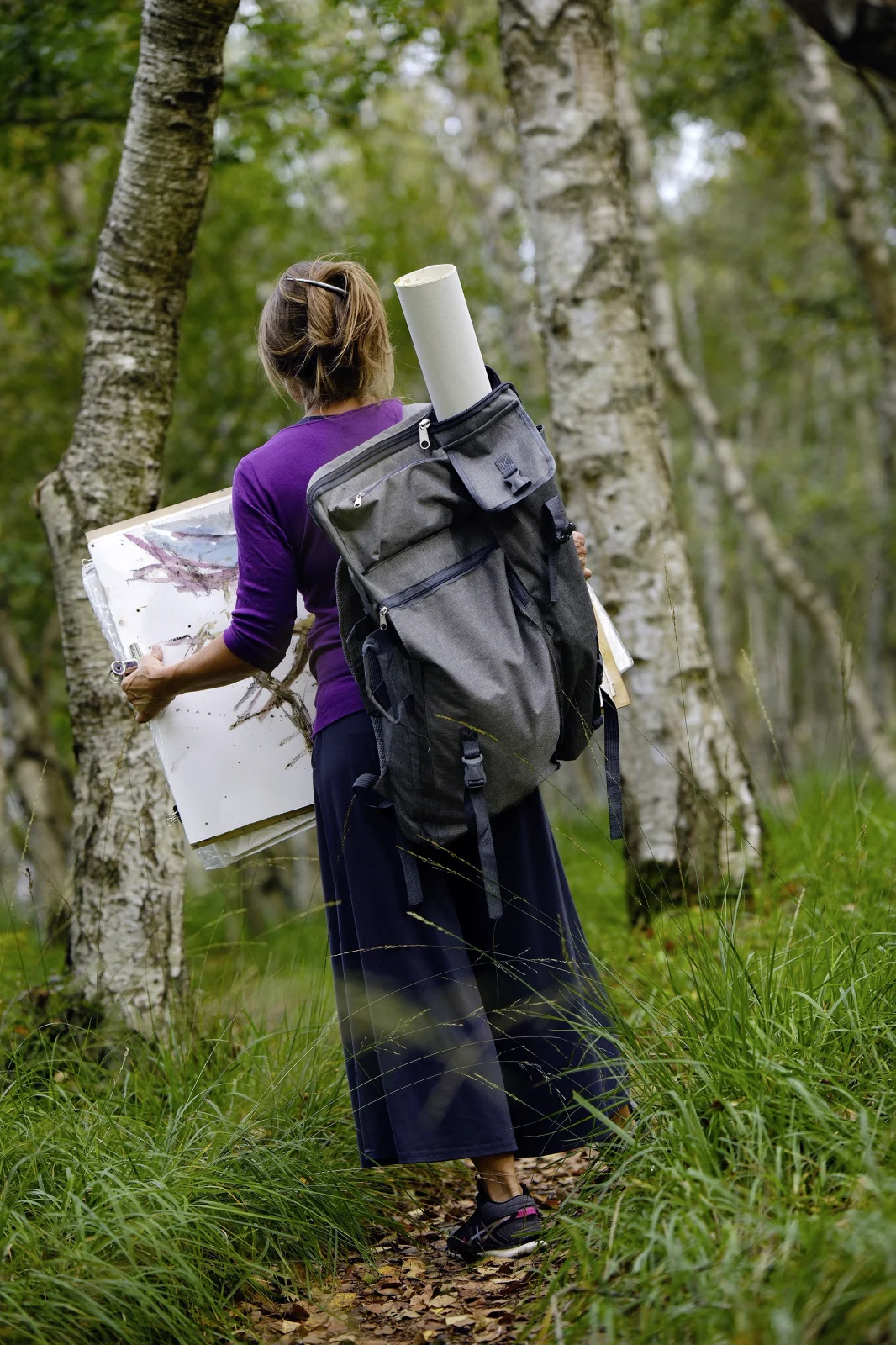 Kerstin Mempel von hinten im Moor vor Birkenstämmen.
