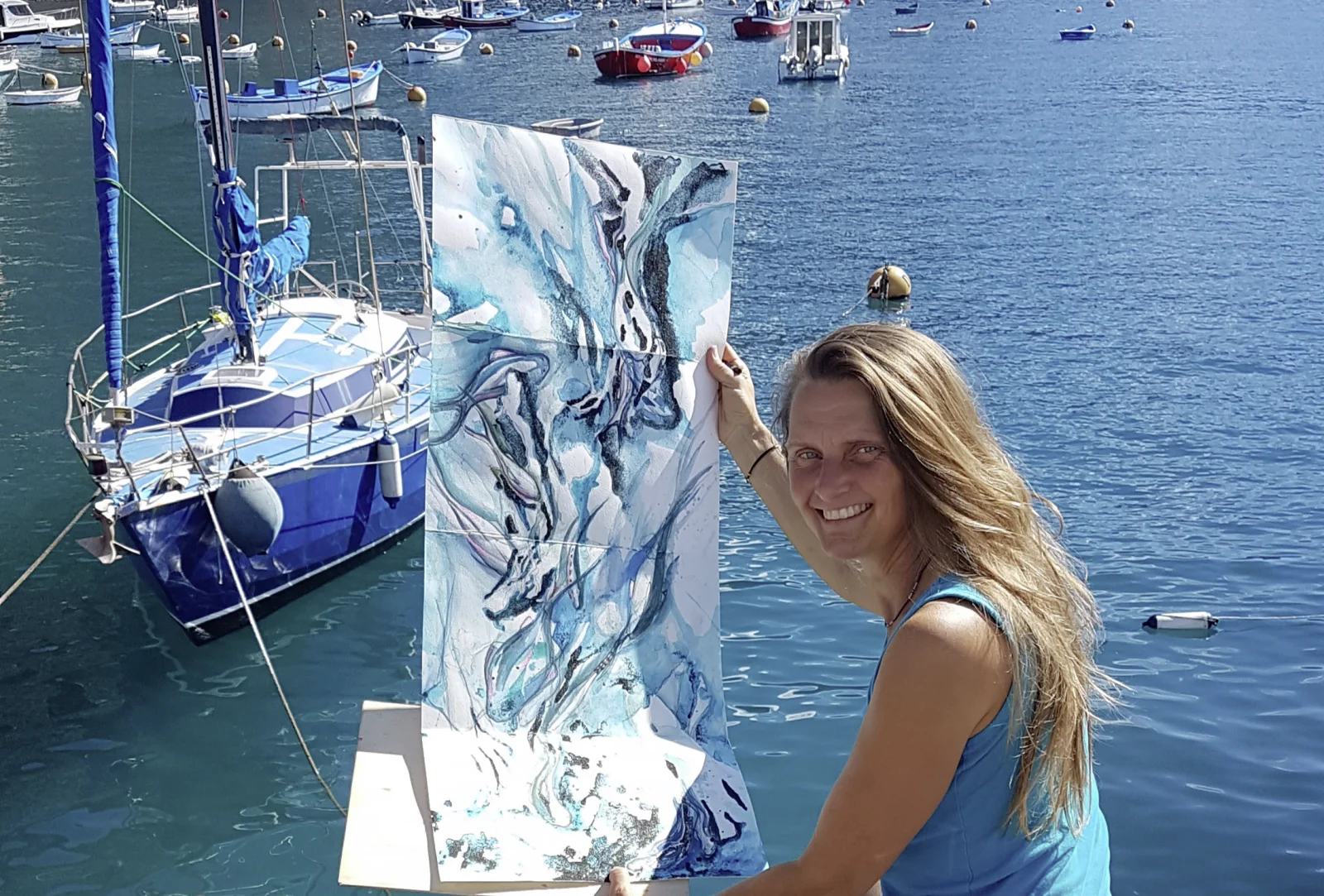 Kerstin Mempel im Hafen von Gomera, ein Bild hochhaltend.