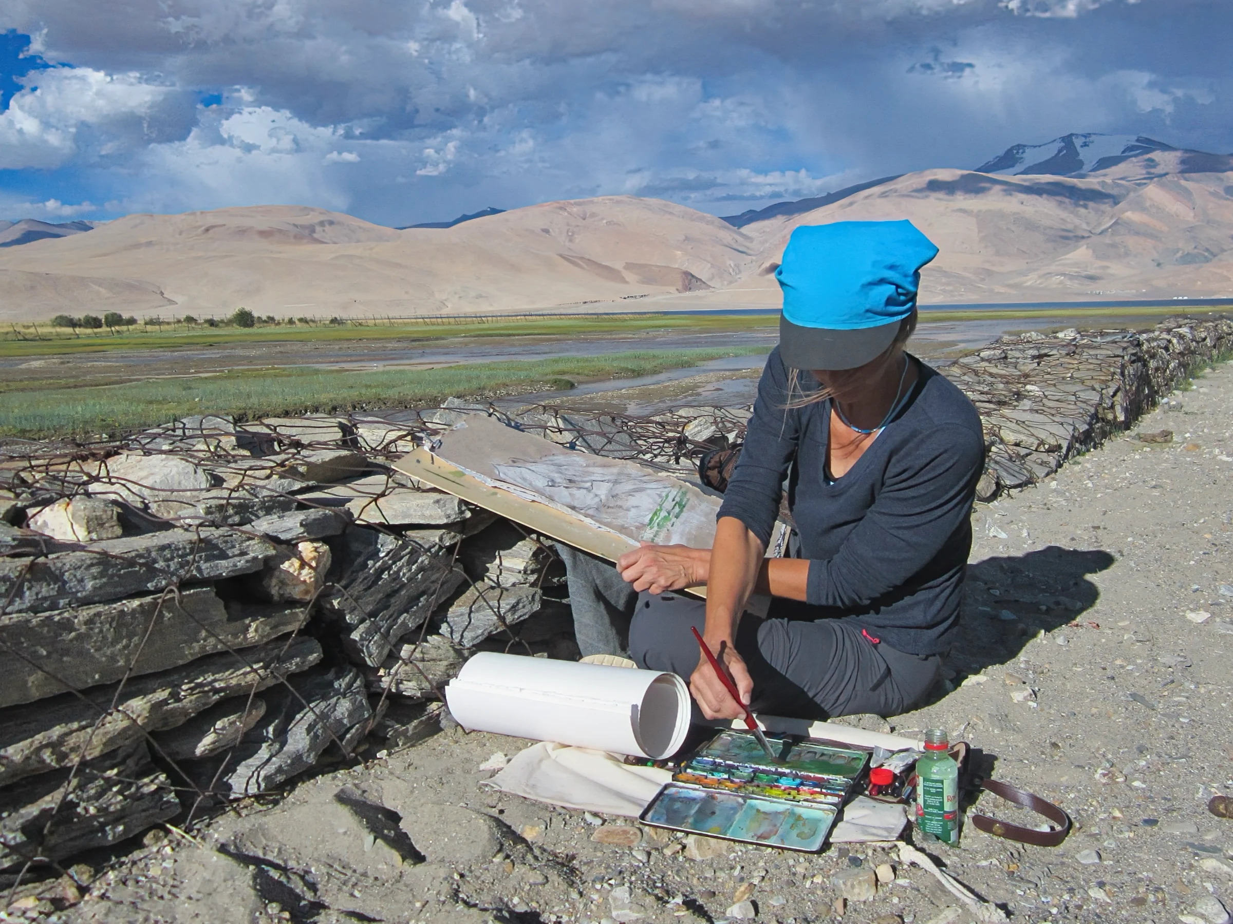 Kerstin Mempel malend in Nepal. Im Hintergrund der Himalaya